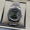 Rolex — esfera verde oscura con bisel estriado y brazalete plateado · 41 mm