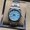 Rolex — esfera azul turquesa con bisel liso y brazalete plateado · 36 mm