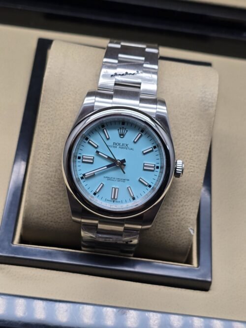 Rolex — esfera azul turquesa con bisel liso y brazalete plateado · 36 mm
