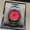 Rolex — esfera roja con bisel liso y brazalete plateado · 36 mm