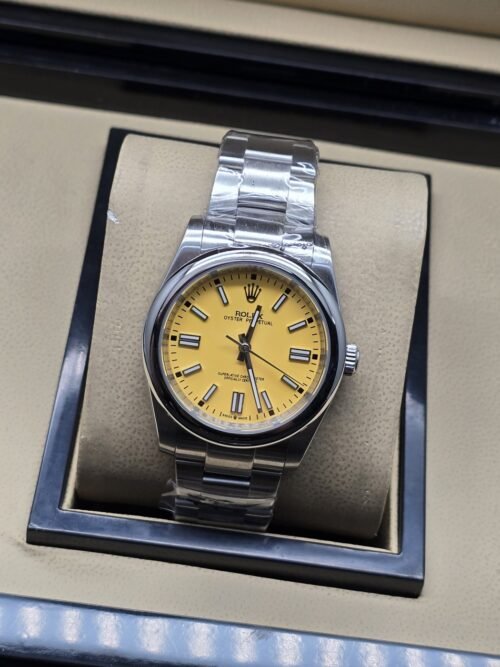 Rolex — esfera amarilla con bisel liso y brazalete plateado · 36 mm