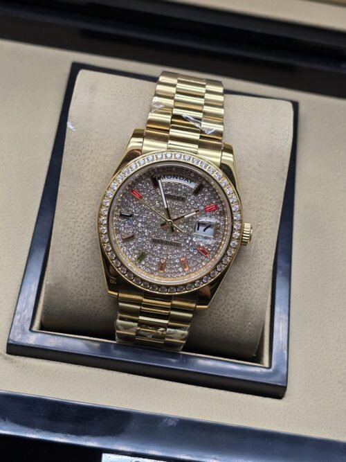 Rolex — esfera plateada brillante con bisel brillante y brazalete dorado · 36 mm