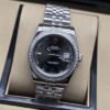 Rolex — esfera negra con bisel brillante y brazalete plateado · 36 mm