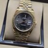 Rolex — esfera negra con bisel dorado estriado y brazalete dorado · 36 mm