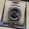 Rolex — esfera negra con bisel brillante rosado y brazalete bicolor · 36 mm