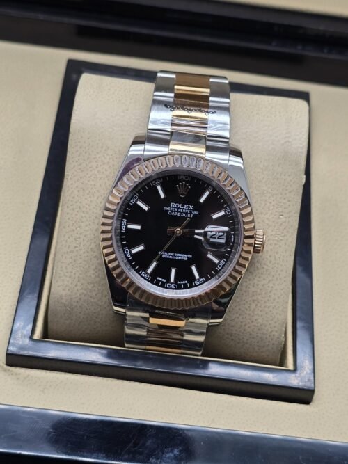Rolex — esfera negra con bisel rosado estriado y brazalete bicolor · 36 mm