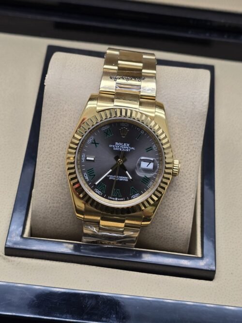 Rolex — esfera negra con bisel dorado estriado y brazalete dorado · 36 mm