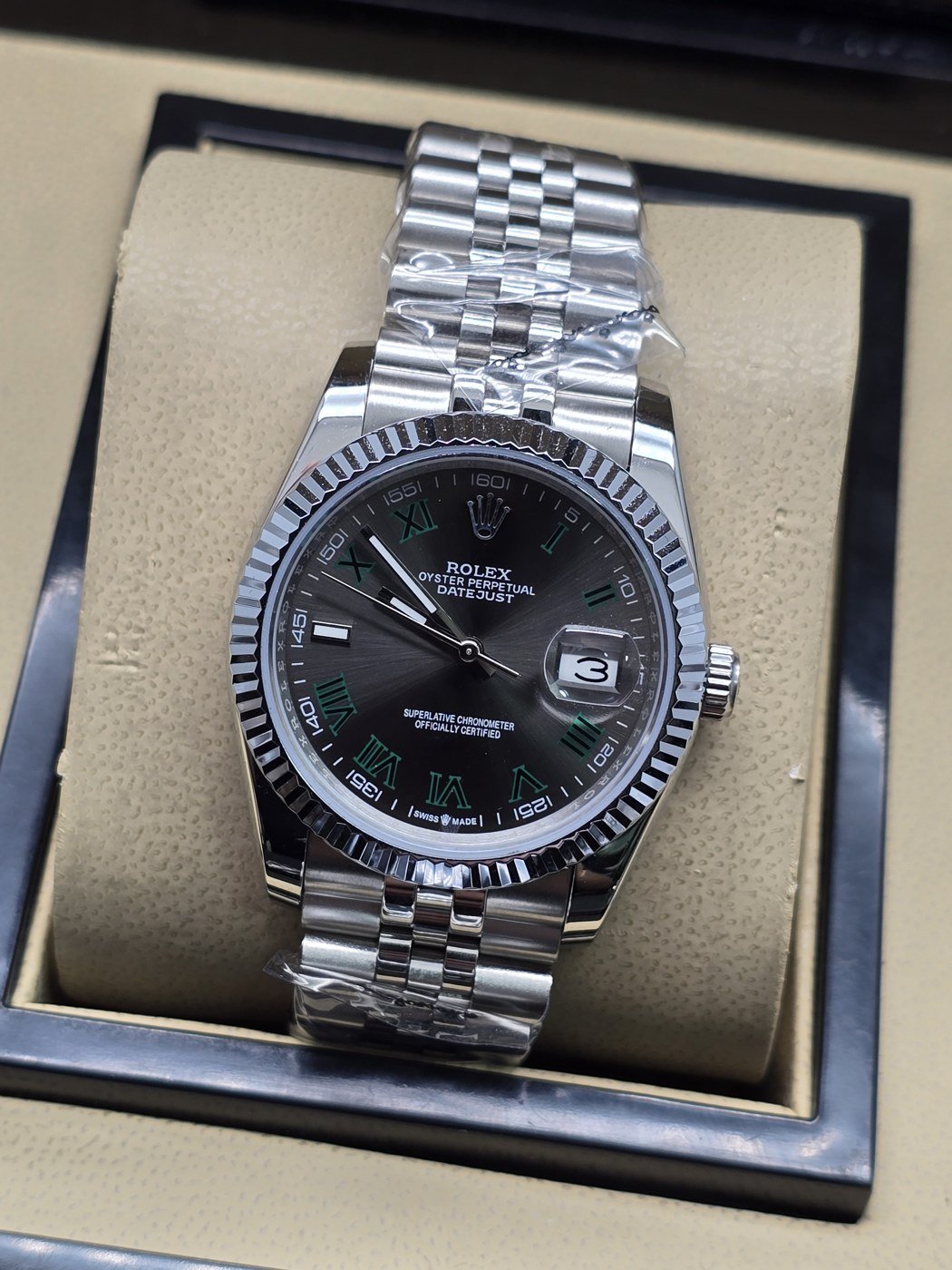 Rolex — esfera negra con bisel estriado y brazalete plateado · 36 mm