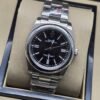Rolex — esfera negra con bisel liso y brazalete plateado · 36 mm