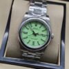 Rolex — esfera verde clara con bisel liso y brazalete plateado · 36 mm