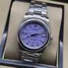 Rolex — esfera lila con bisel liso y brazalete plateado · 36 mm