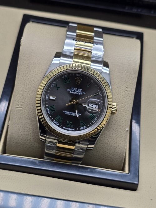 Rolex — esfera negra con bisel dorado estriado y brazalete bicolor · 36 mm