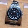 Rolex — esfera negra y bisel oscuro · brazalete plateado
