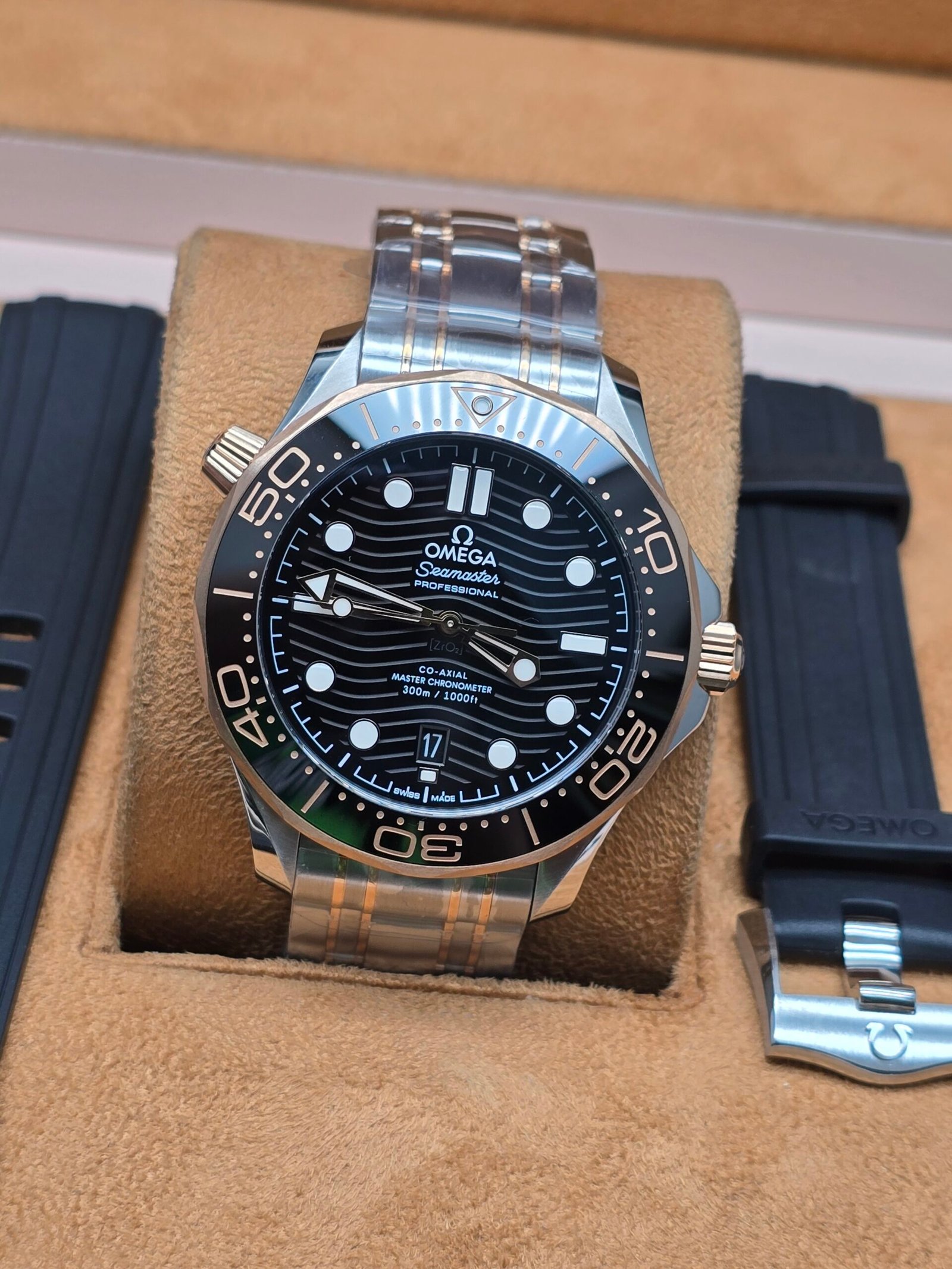 Omega — esfera negra y detalles tono rosado