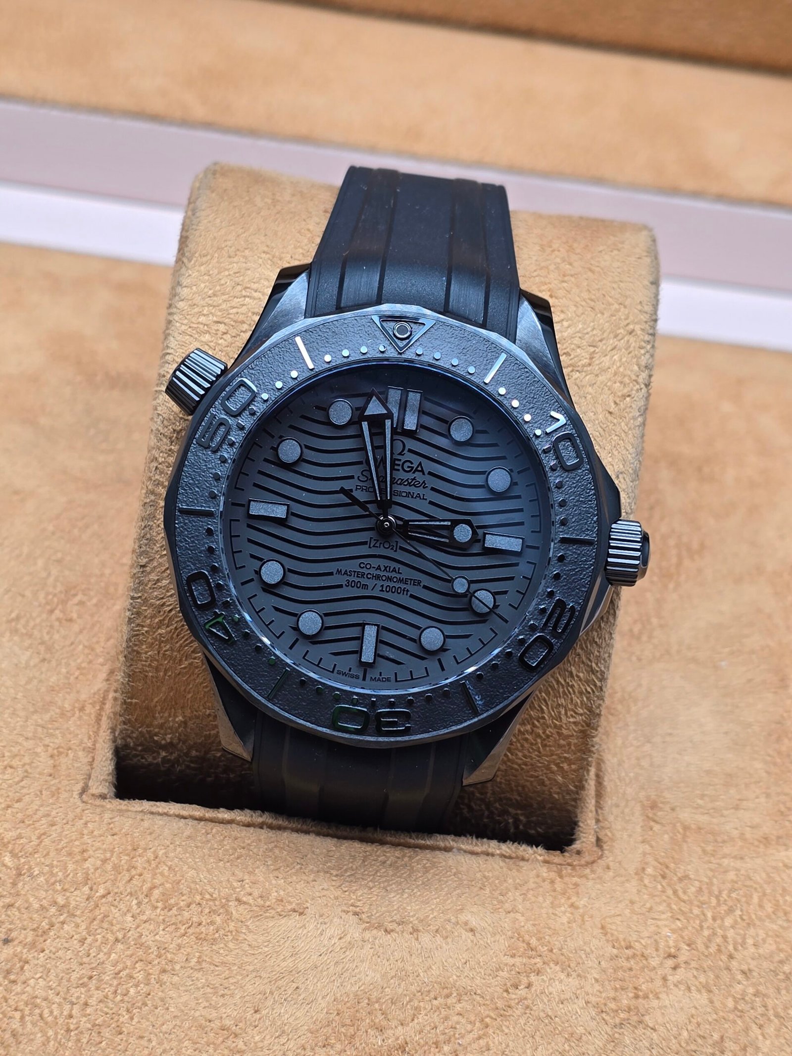 Omega — esfera y caja negras con patrón de ondas