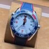 Omega — esfera blanca y correa azul con borde rojo