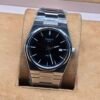 Tissot — esfera negra lisa y brazalete plateado