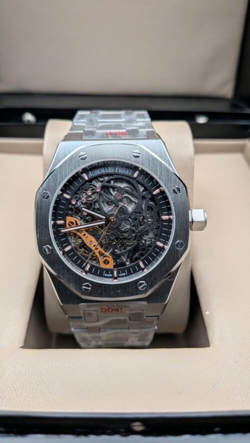 Audemars Piguet — esfera esqueleto con detalles naranjas y brazalete de acero