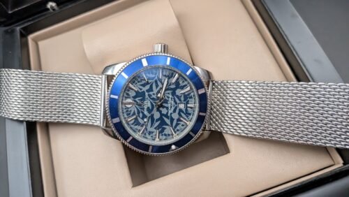 Breitling — esfera azul estampada, bisel azul y brazalete de malla de acero