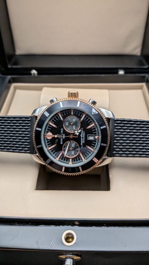 Breitling — cronógrafo con esfera negra, bisel negro con detalles oro rosa y correa de caucho negra