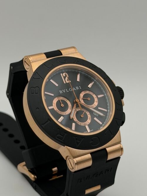 Bvlgari — cronógrafo con esfera negra, caja oro rosa, bisel negro y correa de caucho negra
