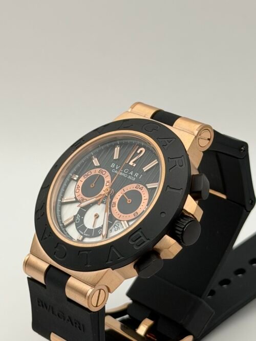 Bvlgari — cronógrafo con esfera negra y detalle esqueleto, caja oro rosa y correa de caucho negra