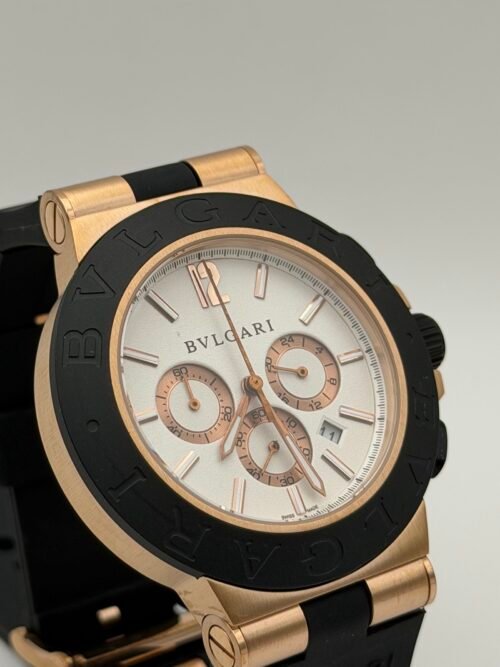 Bvlgari — cronógrafo con esfera blanca, caja oro rosa, bisel negro y correa de caucho negra