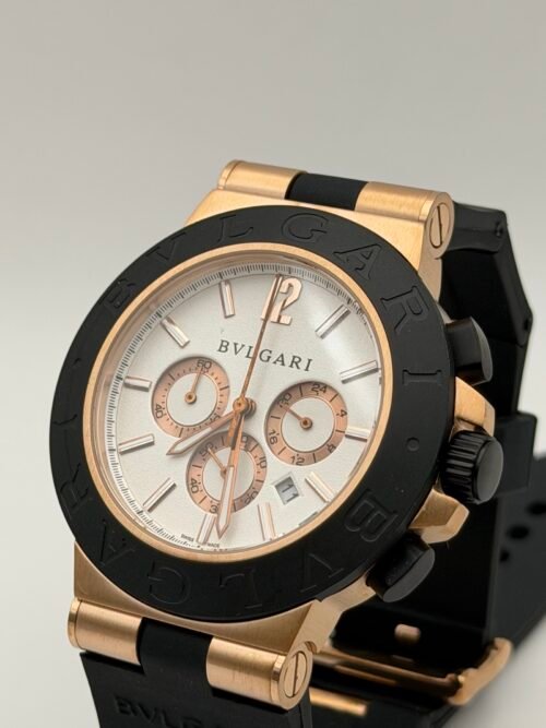Bvlgari — cronógrafo con esfera blanca, caja oro rosa, bisel negro y correa de caucho negra