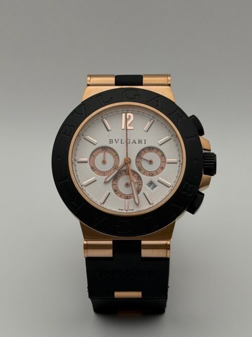 Bvlgari — cronógrafo con esfera blanca, caja oro rosa, bisel negro y correa de caucho negra