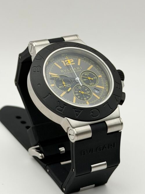 Bvlgari — cronógrafo con esfera gris y detalles amarillos, bisel negro y correa de caucho negra