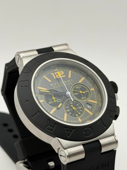 Bvlgari — cronógrafo con esfera gris y detalles amarillos, bisel negro y correa de caucho negra