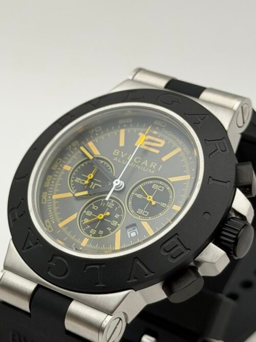 Bvlgari — cronógrafo con esfera gris y detalles amarillos, bisel negro y correa de caucho negra
