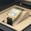 Cartier — caja rectangular con bisel dorado, esfera blanca y correa de cuero negra