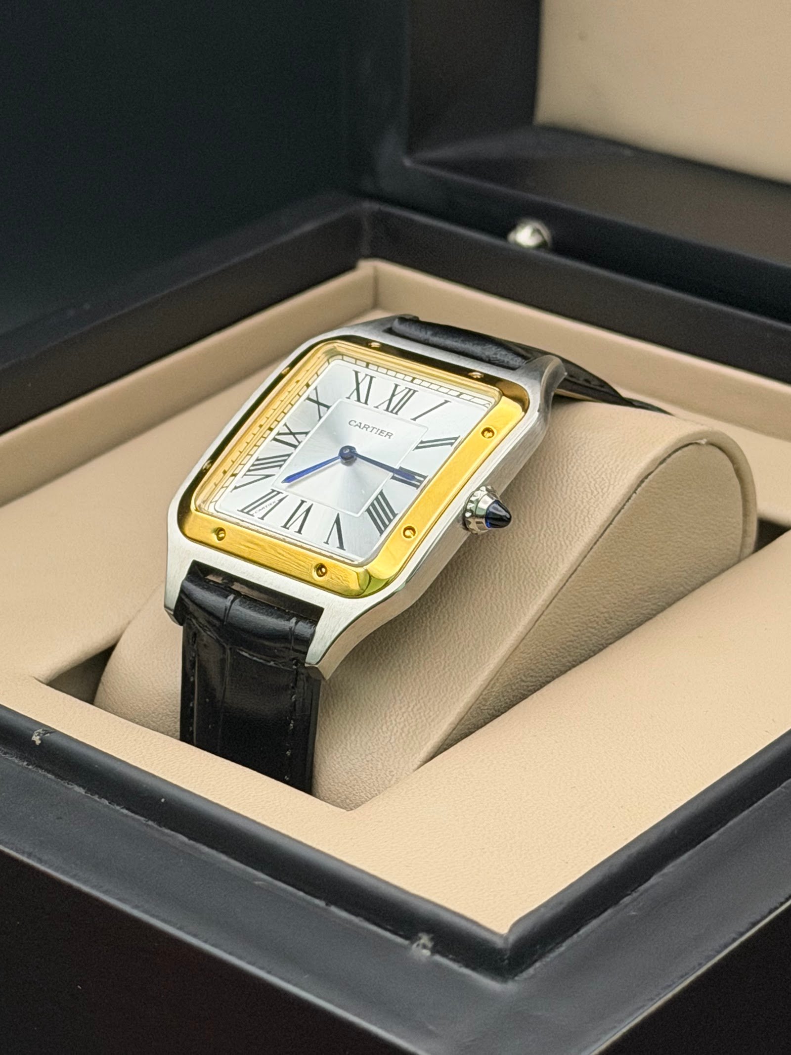 Cartier — caja rectangular con bisel dorado, esfera blanca y correa de cuero negra