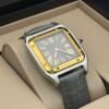 Cartier — caja rectangular con bisel dorado, esfera gris y correa de cuero gris