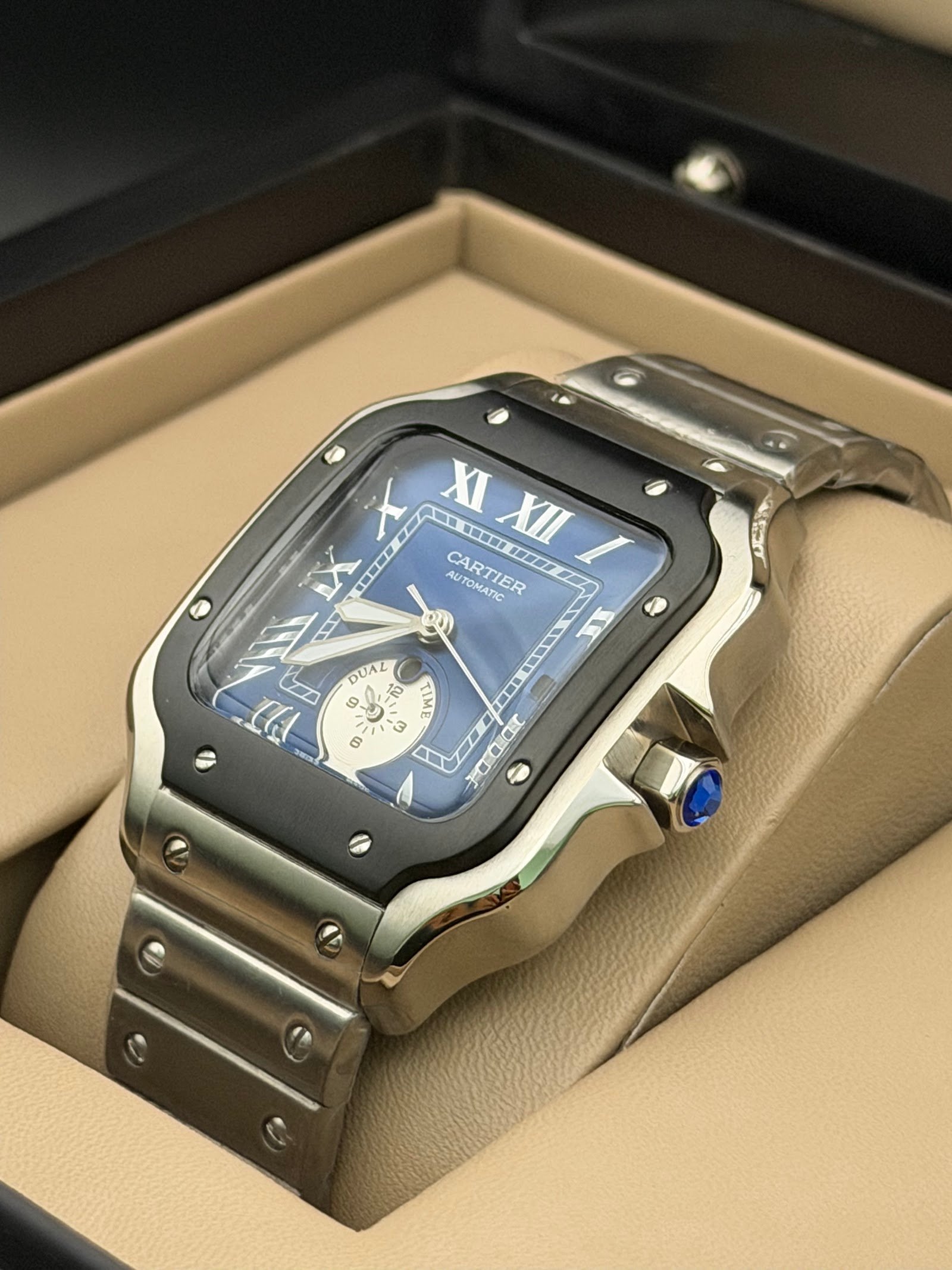 Cartier — caja cuadrada con bisel negro, esfera azul con volante a la vista y brazalete de acero