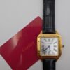 Cartier — caja rectangular dorada, esfera blanca con números romanos y correa de cuero negra