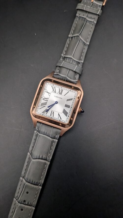 Cartier — caja rectangular oro rosa, esfera blanca con números romanos y correa de cuero gris