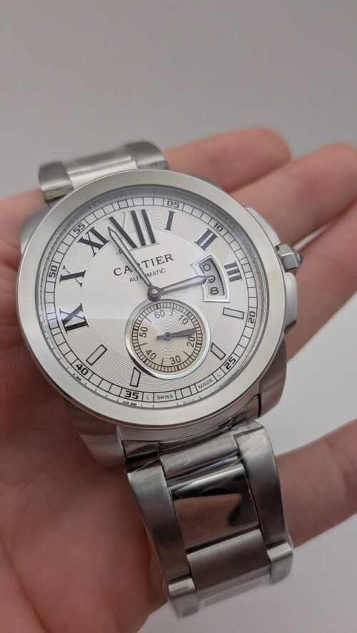 Cartier — esfera blanca con números romanos y segundero pequeño, brazalete de acero