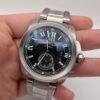 Cartier — esfera negra con números romanos y segundero pequeño, brazalete de acero