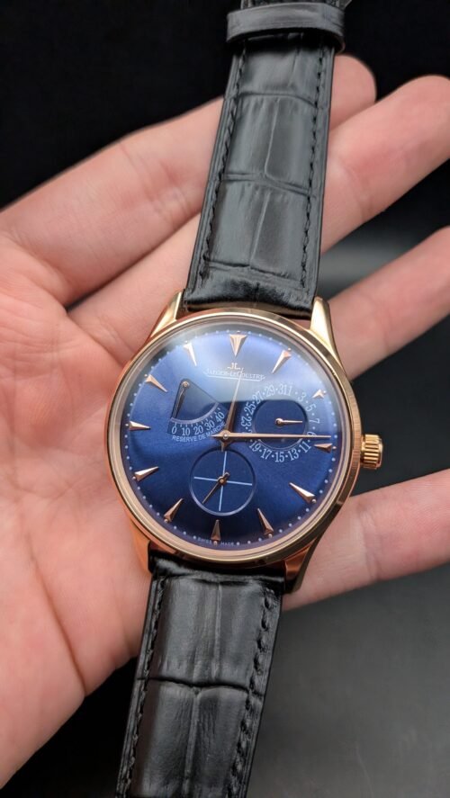 Jaeger-LeCoultre — esfera azul con reserva de marcha, caja oro rosa y correa de cuero negra en mano