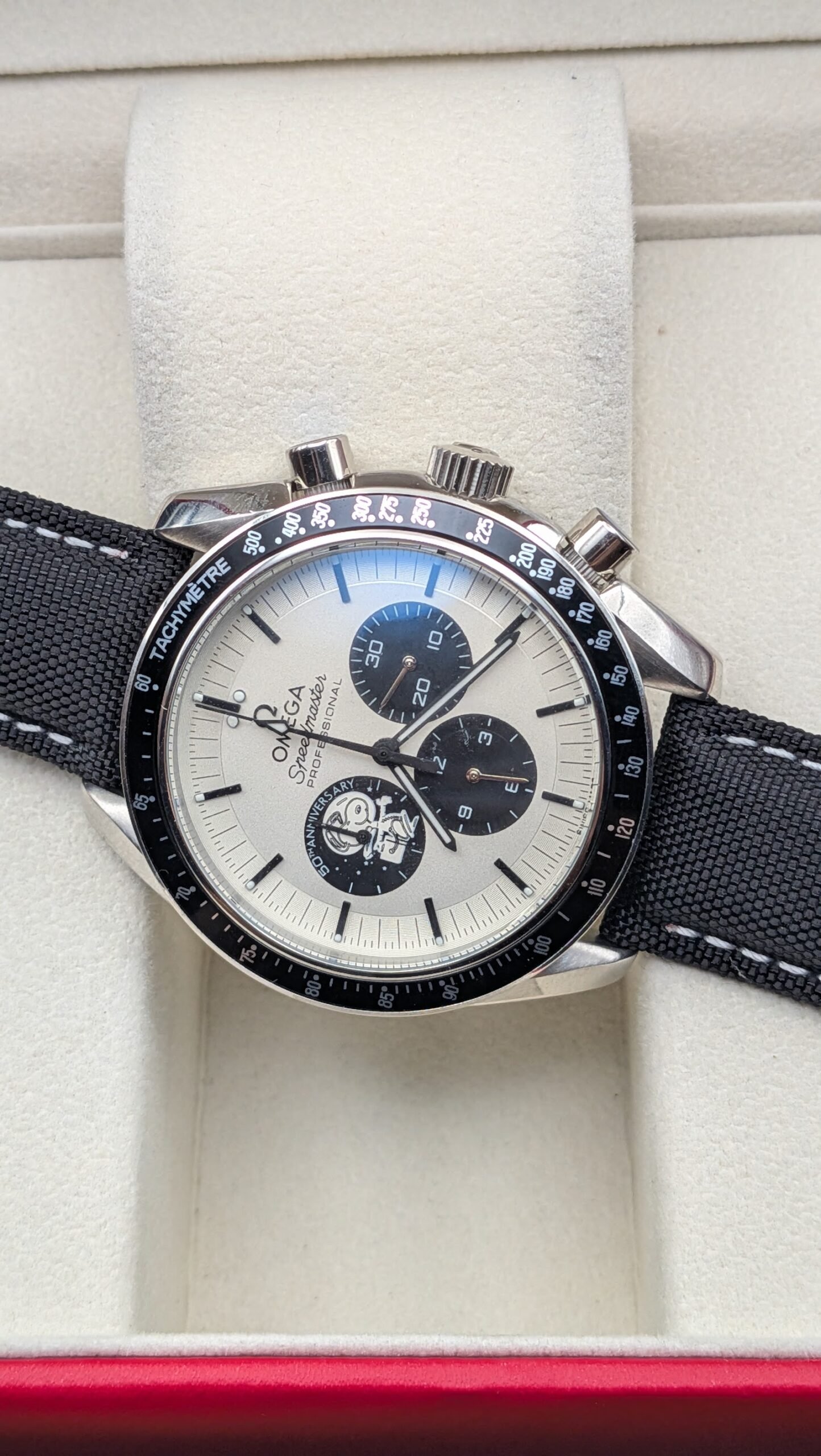 Omega — cronógrafo con esfera blanca y subesferas negras, caja de acero y correa de tela negra
