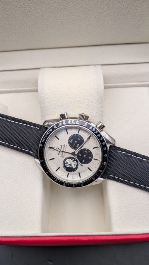 Omega — cronógrafo con esfera blanca y subesferas negras, caja de acero y correa de tela negra