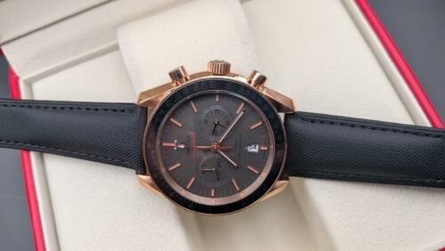 Omega — cronógrafo con esfera gris, caja oro rosa y correa de tela negra
