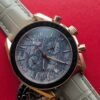 Omega — cronógrafo con esfera gris texturizada, caja oro rosa y correa de cuero gris