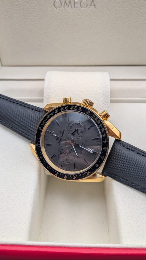 Omega — cronógrafo con esfera gris oscura, caja dorada y correa de tela negra