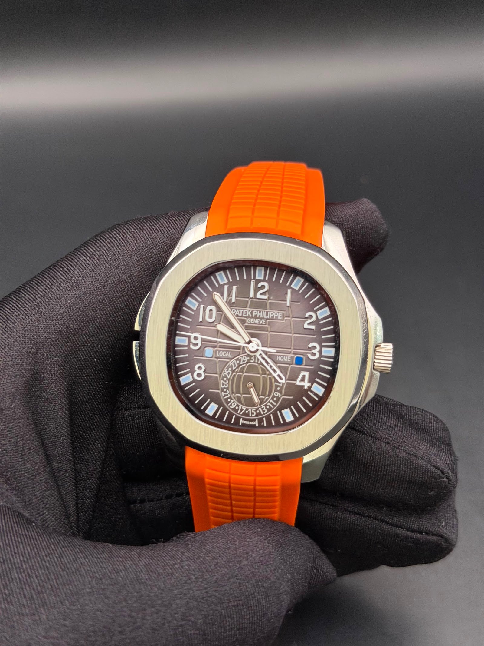 Patek Philippe — esfera marrón con números grandes y correa de caucho naranja