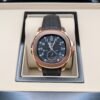Patek Philippe — esfera negra con doble huso horario, caja oro rosa y correa de caucho negra