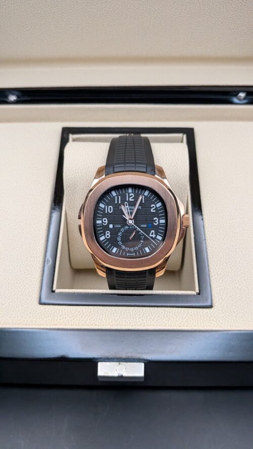 Patek Philippe — esfera negra con doble huso horario, caja oro rosa y correa de caucho negra