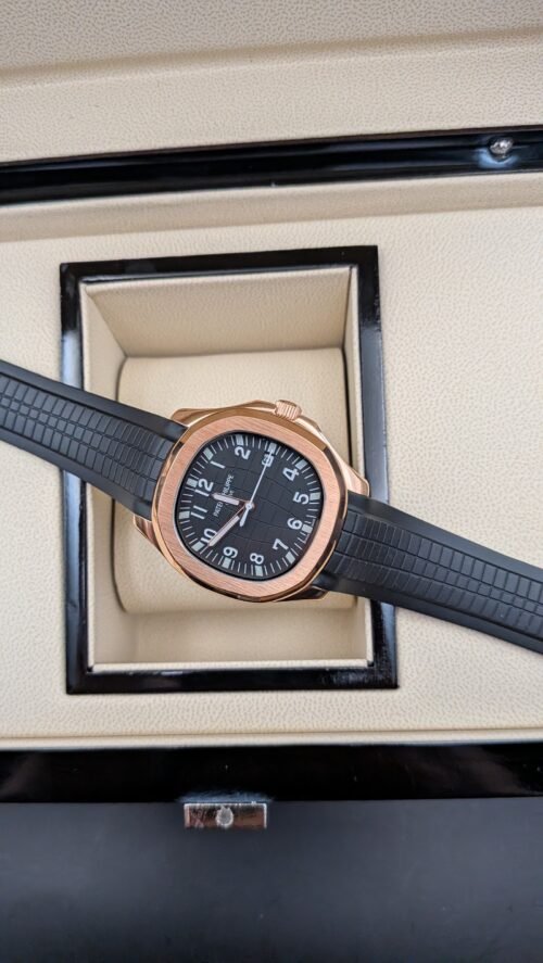 Patek Philippe — esfera negra con números grandes, caja oro rosa y correa de caucho negra